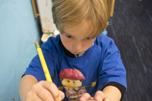 boy with pencil at easle